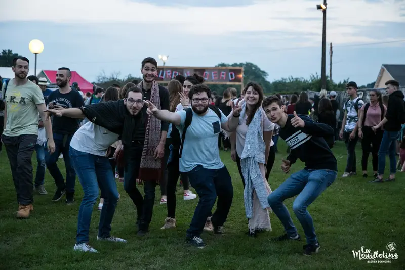 Des festivaliers dansent sur la pelouse en soirée - photo Bastien Bonhoure