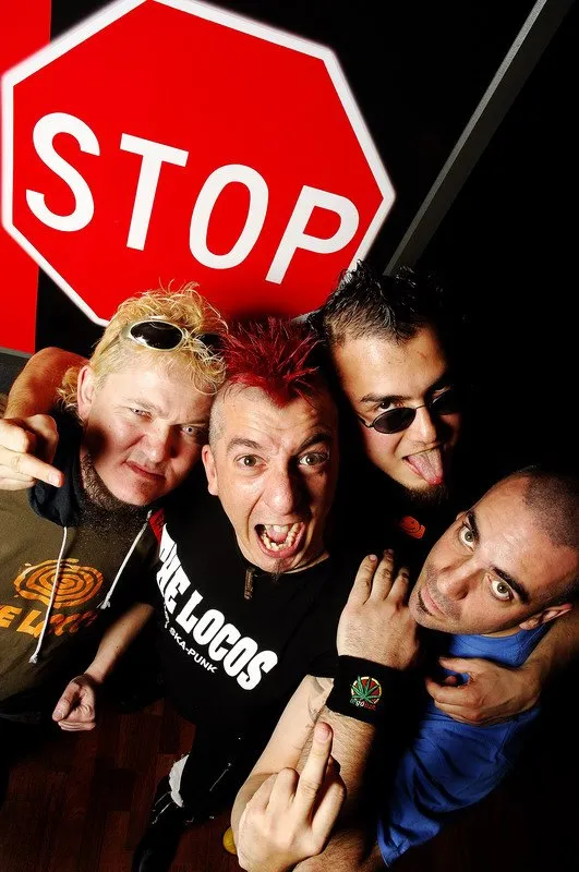 Les membres de The Locos devant un panneau stop