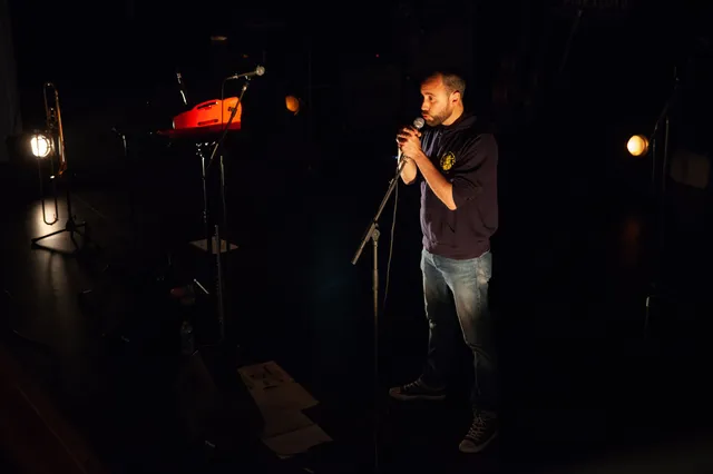 Un musicien à l’harmonica seul sur scène - photo AMAC / Les Mouillotins