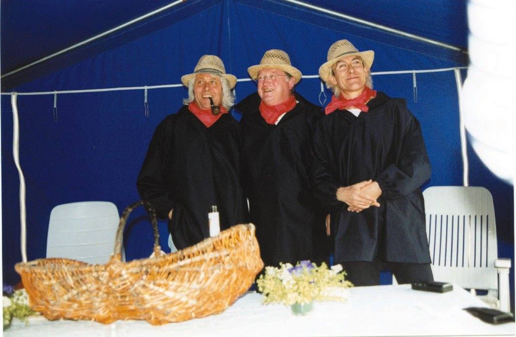 Trois Mouillotins en tenue traditionnelle avec le panier de la collecte d’œufs
