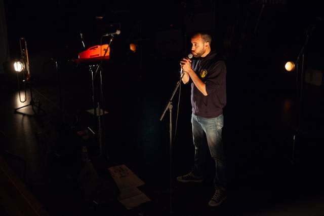Un musicien à l’harmonica seul sur scène - photo AMAC / Les Mouillotins