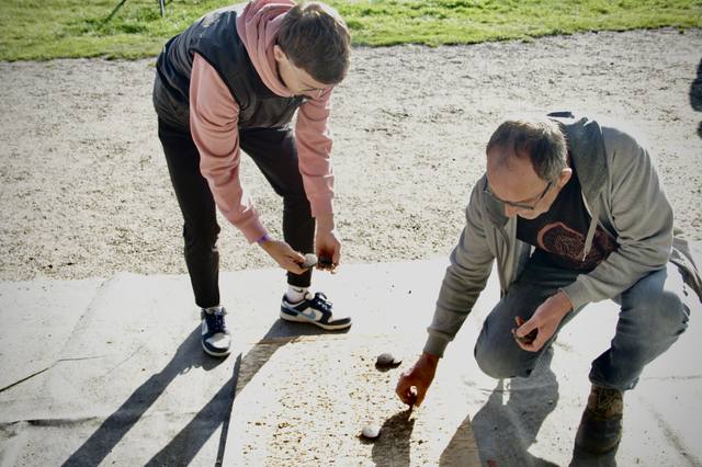Des joueurs ramassent leurs palets sur la piste - photo AMAC / Les Mouillotins