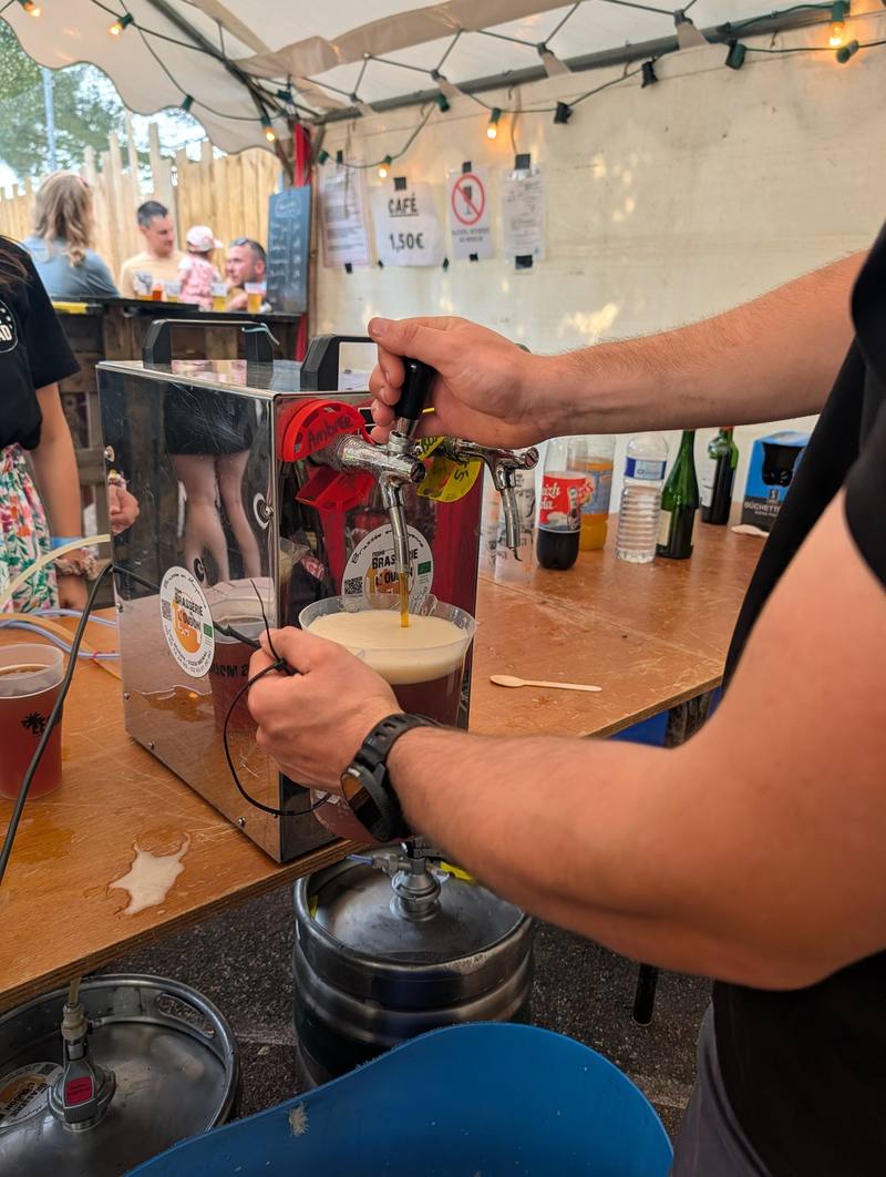 Un bénévole tire une bière à la pression au bar - photo Alexandre Audebeau