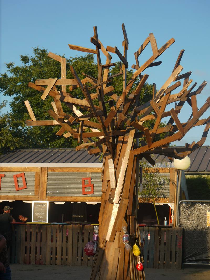 L'arbre sculpté devant les stands en bois - photo AMAC / Les Mouillotins