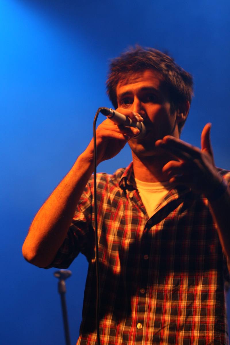 Le chanteur de KKC Orchestra sous les projecteurs bleus - photo AMAC / Les Mouillotins