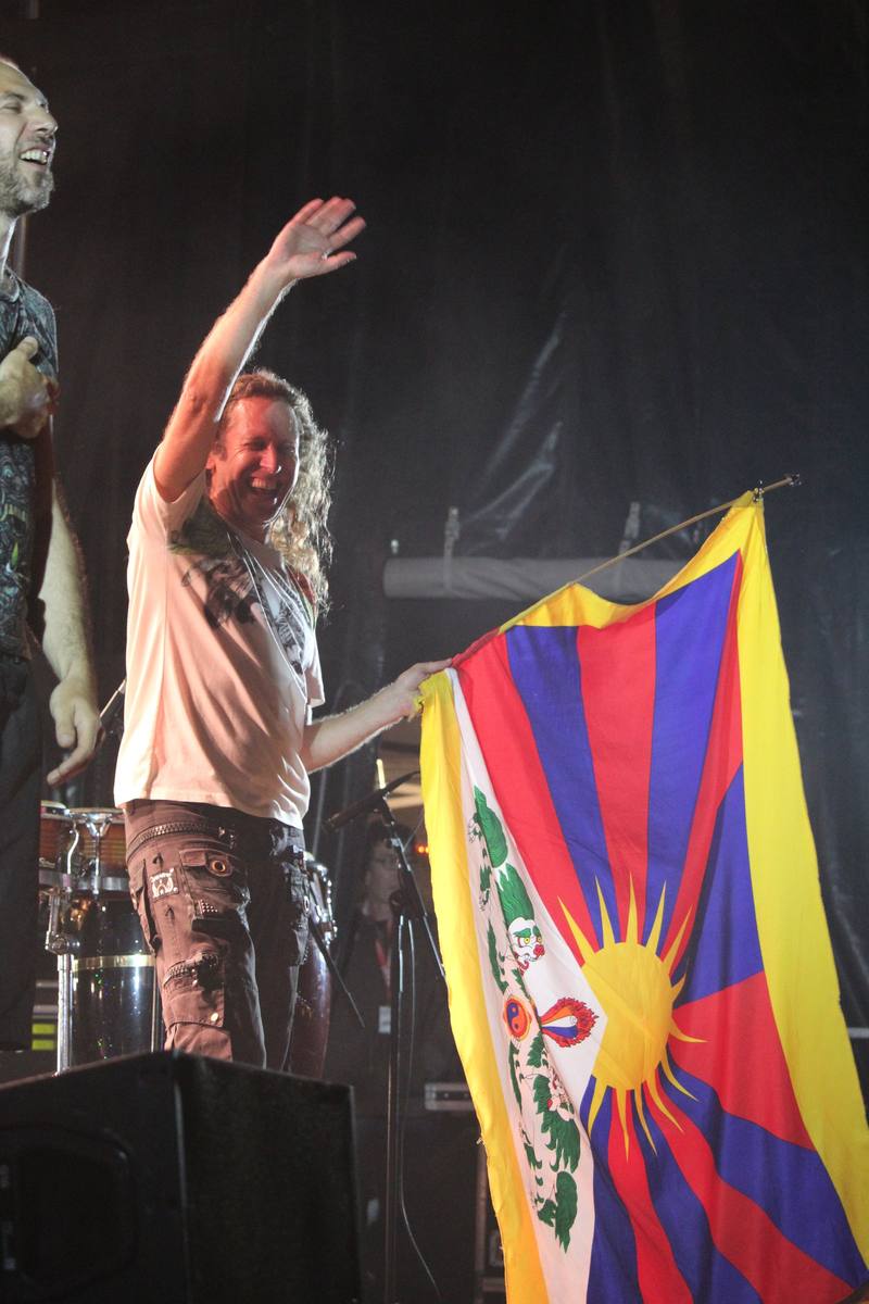 Un musicien brandit un drapeau face au public en fin de nuit - photo AMAC / Les Mouillotins
