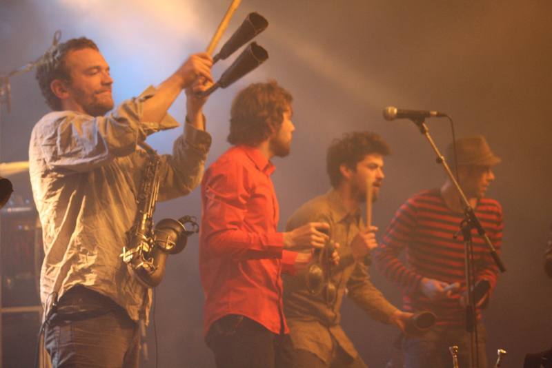 Des cuivres et percussions sur scène dans la lumière chaude - photo AMAC / Les Mouillotins