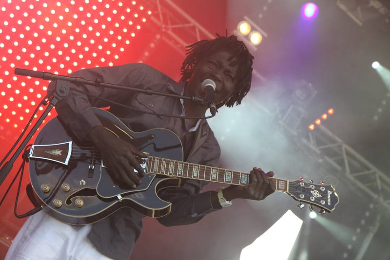 Un guitariste sur fond rouge à pois blancs - photo AMAC / Les Mouillotins
