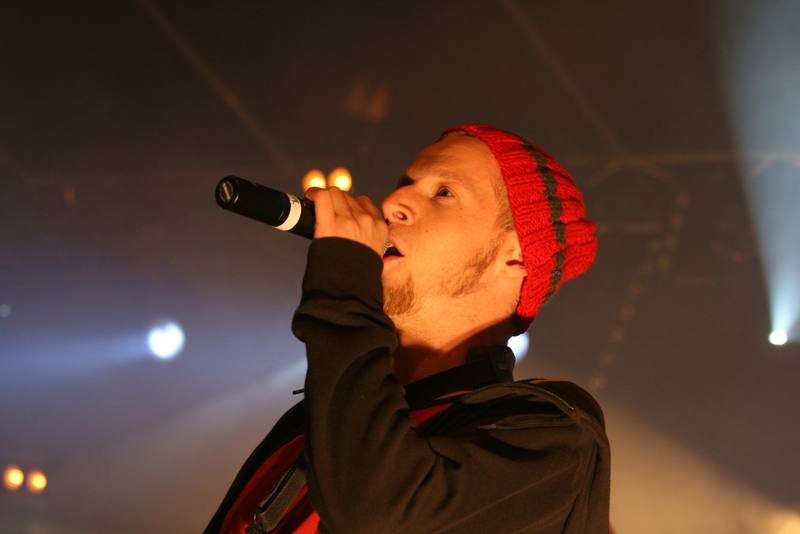 Un chanteur en bonnet rouge au micro - photo AMAC / Les Mouillotins