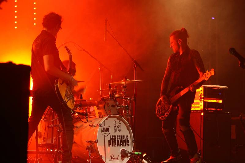 Les Fatals Picards sur scène dans les lumières rouges - photo AMAC / Les Mouillotins