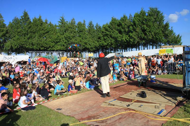 Un spectacle de rue devant le public installé dans l'herbe - photo AMAC / Les Mouillotins