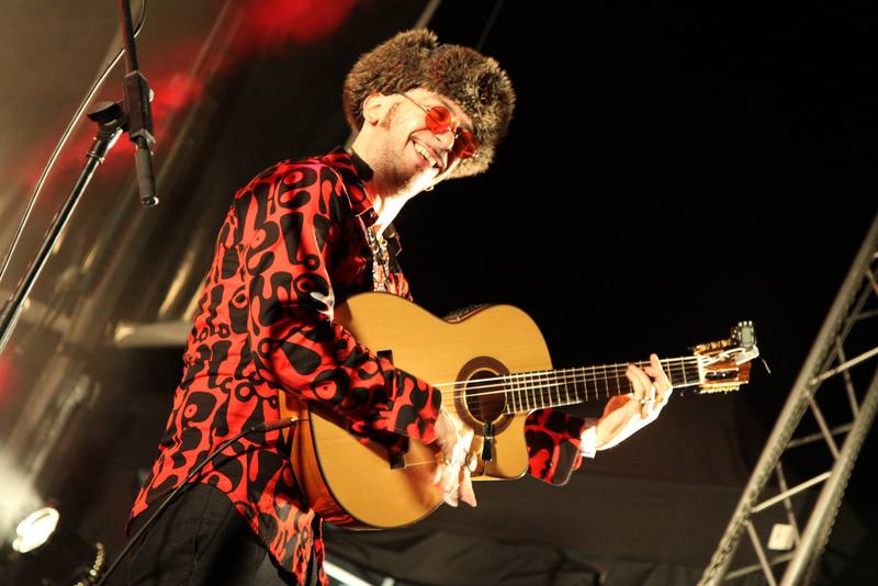 Un guitariste en chemise imprimée sur scène, de nuit - photo AMAC / Les Mouillotins