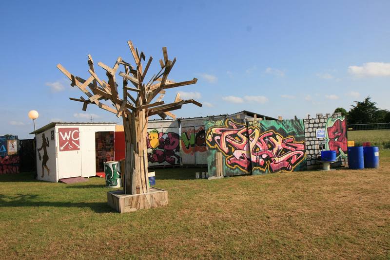 Le site en fin de journée, avec l'arbre sculpté et les conteneurs graffés - photo AMAC / Les Mouillotins