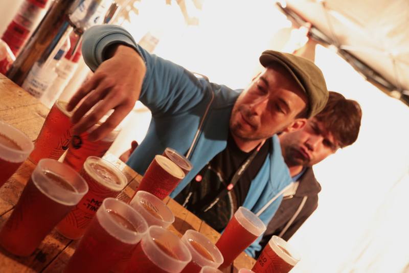 Un bénévole sert une bière au bar en fin de nuit - photo Bastien Bonhoure