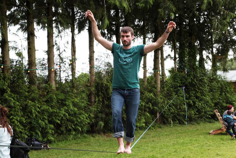 Un festivalier sur la slackline entre les arbres - photo Bastien Bonhoure
