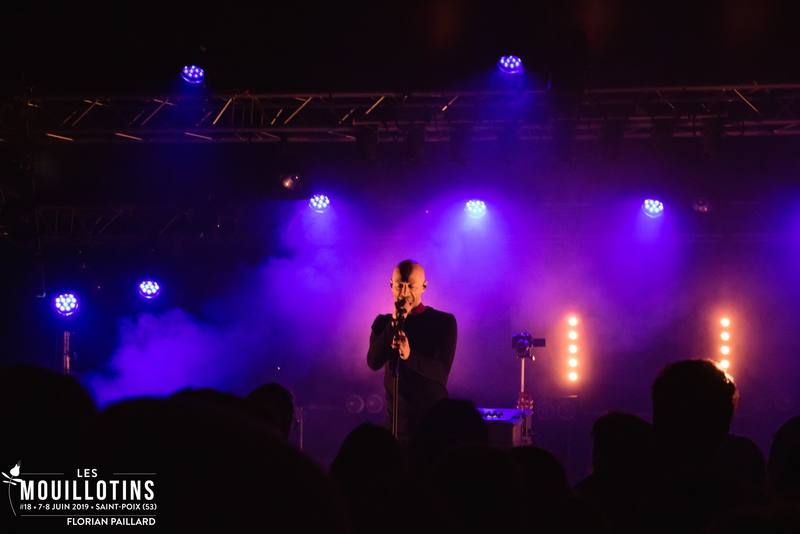 Un chanteur sur scène sous les lumières violettes, le vendredi soir - photo Florian Paillard