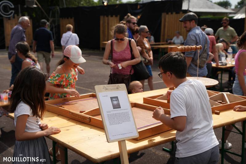 Festivaliers de tous âges autour des jeux en bois l'après-midi - photo AMAC / Les Mouillotins