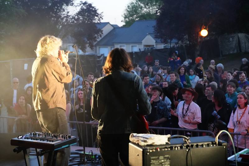 Johnny Jane en concert face au public au coucher du soleil, vu depuis la scène - photo AMAC / Les Mouillotins