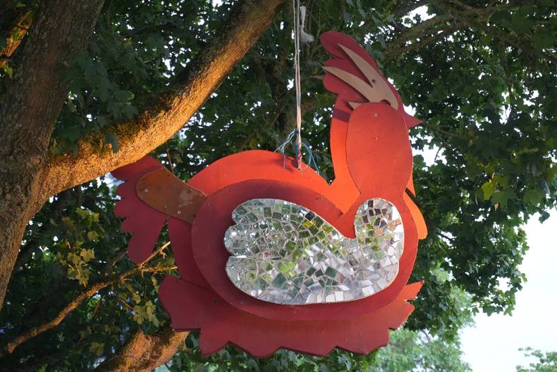 Le coq en bois et miroirs suspendu dans un arbre du site - photo Coline & Flo