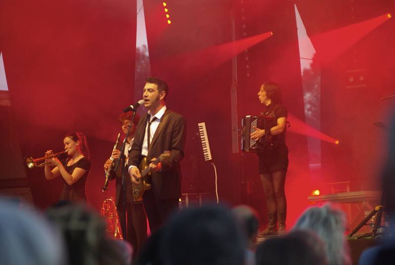 Un groupe avec trompette et accordéon sous les projecteurs rouges - photo AMAC / Les Mouillotins