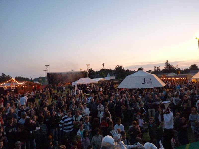 Le public sur le site au coucher du soleil, chapiteaux en arrière-plan - photo AMAC / Les Mouillotins