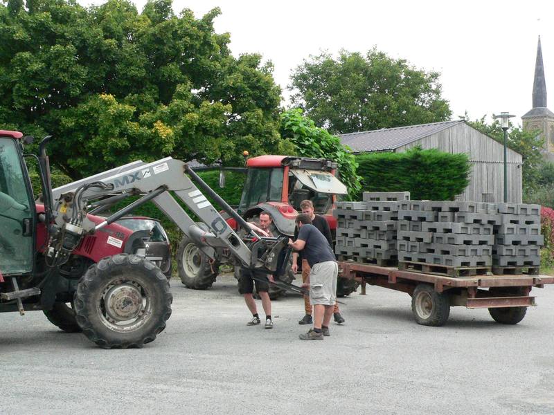 Des bénévoles chargent des palettes avec un tracteur pour le montage - photo AMAC / Les Mouillotins