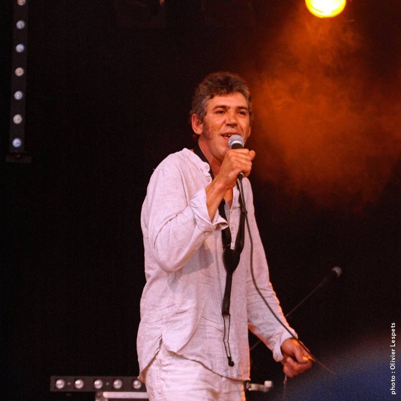 Un chanteur sur scène dans la lumière orangée - photo Olivier Lespets