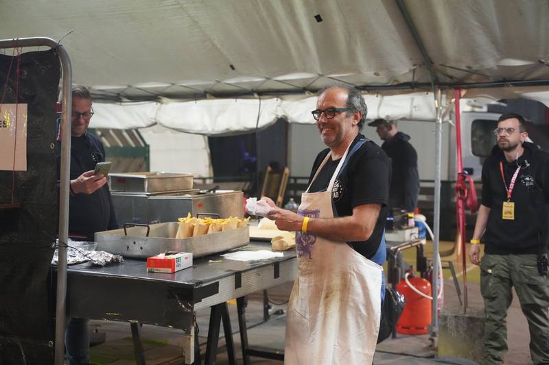 Bénévole restauration souriant au stand frites - photo AMAC / Les Mouillotins